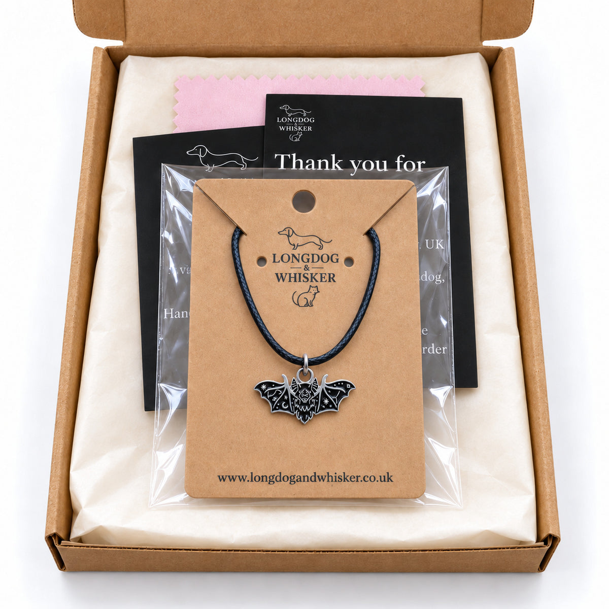 Black fanged bat necklace on black cord in Longdog & Whisker gift-ready packaging