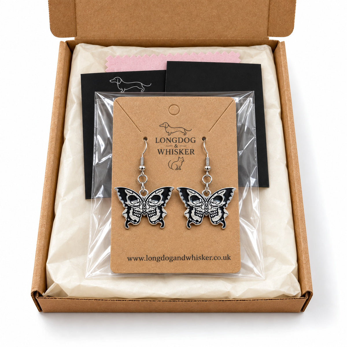 Double skull butterfly earrings presented in Longdog & Whisker packaging