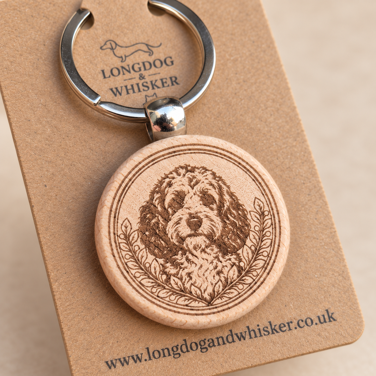 Close-up of Cockapoo portrait and leafy border on the wooden keyring, with silver connector