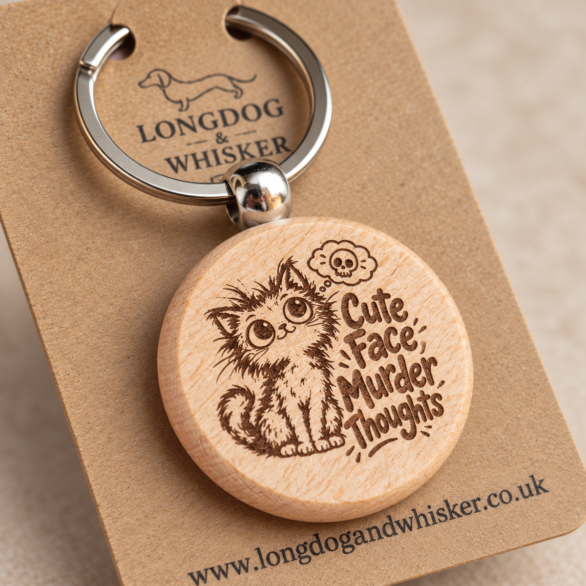 Close-up of the kitten and skull thought bubble on the Cute Face Murder Thoughts wooden keyring