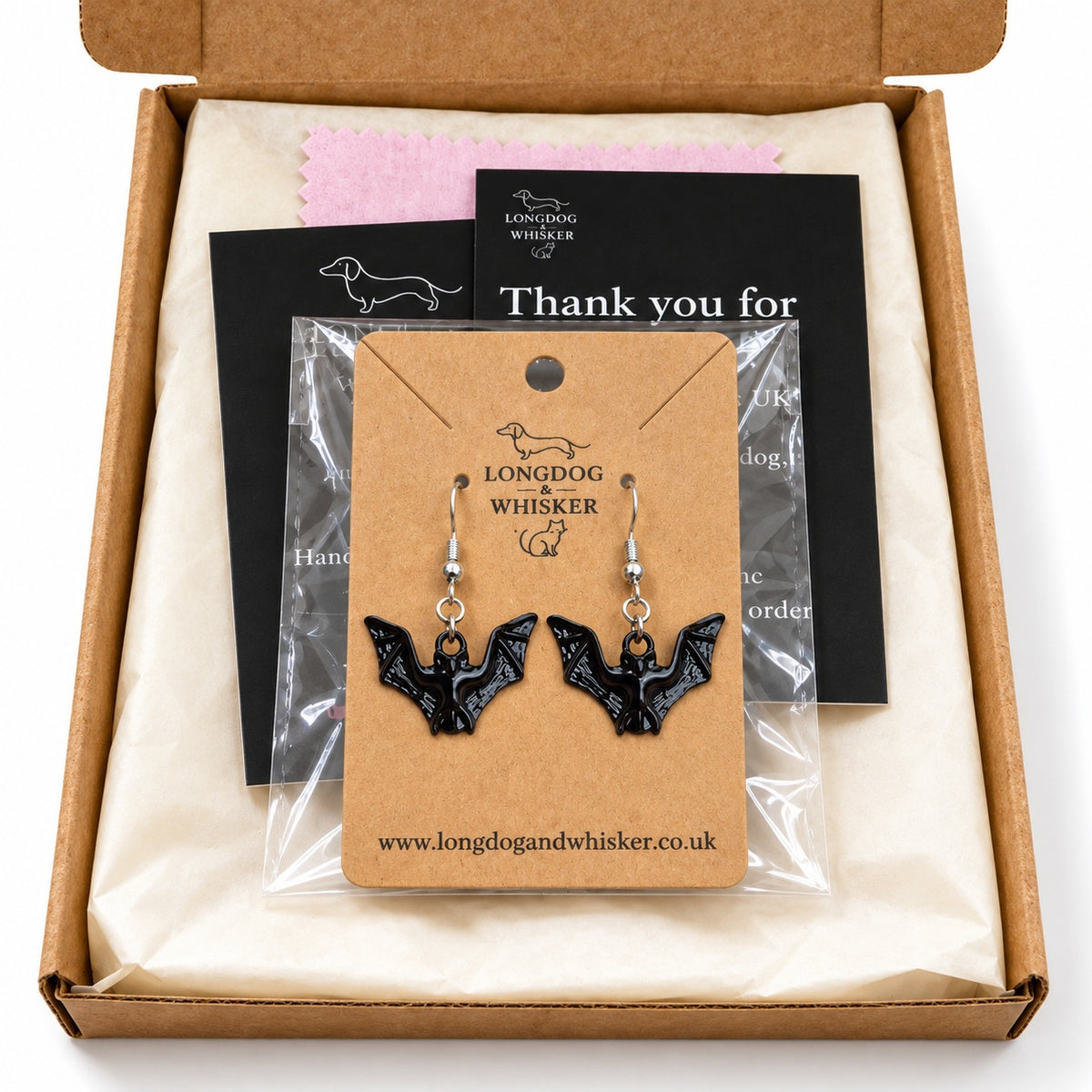 Gloss black bat drop earrings on their kraft card inside Longdog & Whisker packaging