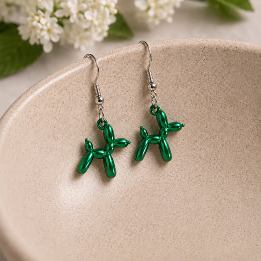 Green Balloon Dog Earrings hanging from a ceramic bowl