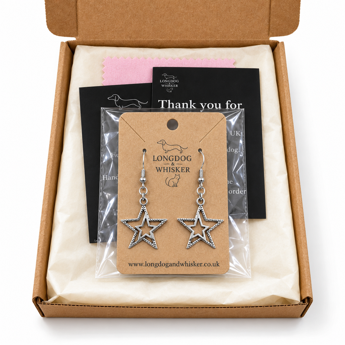 Silver double star earrings on their kraft card in Longdog & Whisker postal packaging.