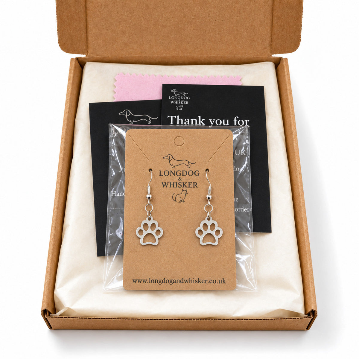 Silver paw print earrings presented in Longdog & Whisker packaging