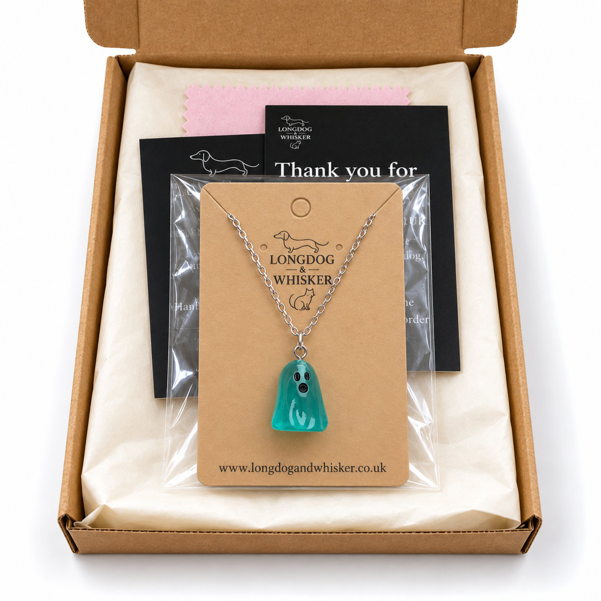 Aqua ghost necklace on its display card in Longdog & Whisker postal packaging.