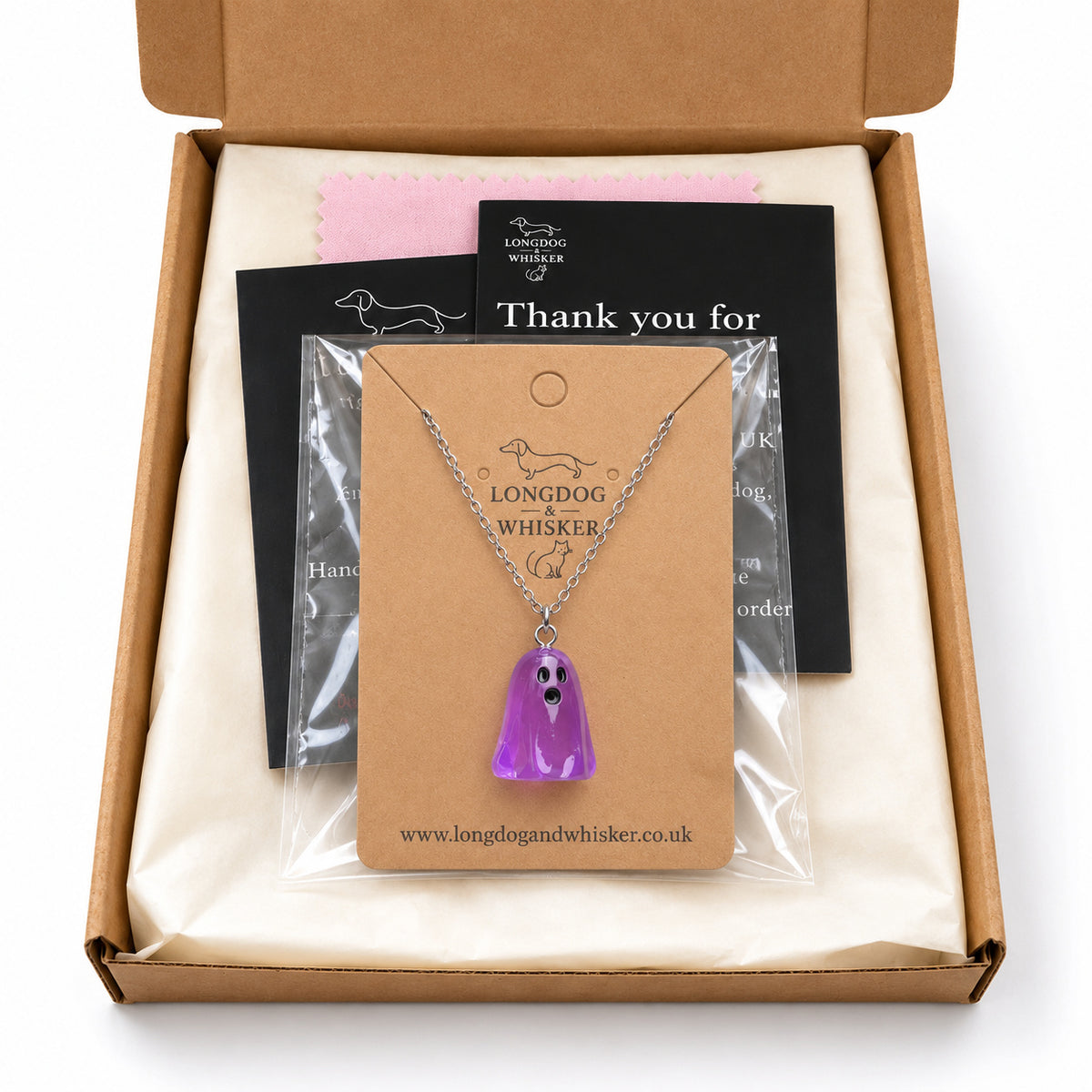 Translucent purple ghost necklace on its card in Longdog & Whisker postal packaging.