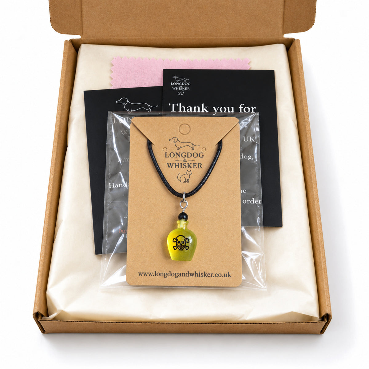 Yellow poison bottle necklace on black cord in Longdog & Whisker postal packaging.