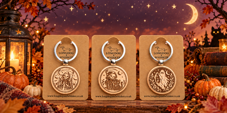Three engraved wooden Halloween keyrings on Longdog & Whisker kraft cards in an autumn scene