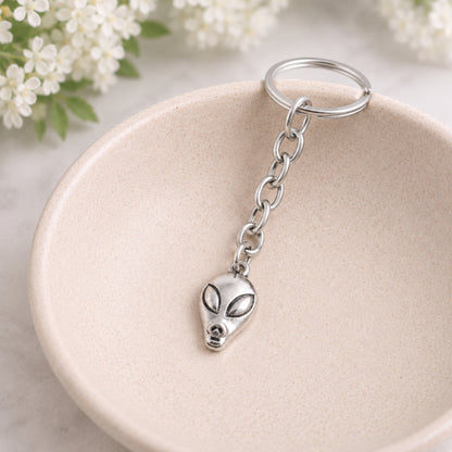 Alien head key chain bag charm styled in a ceramic bowl