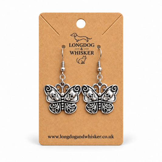 Silver-tone skull butterfly earrings with a vintage brushed effect on a Longdog & Whisker kraft card