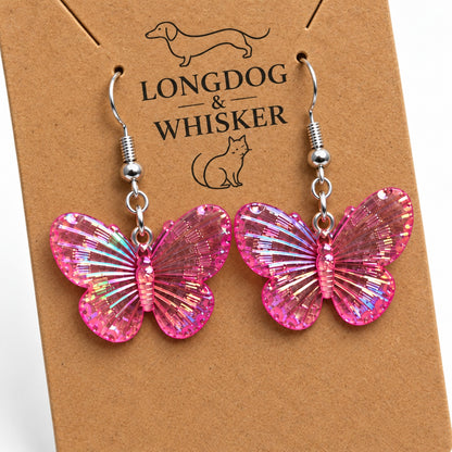 Close-up of Hot Pink Aurora Butterfly Earrings showing rainbow iridescent wing detail