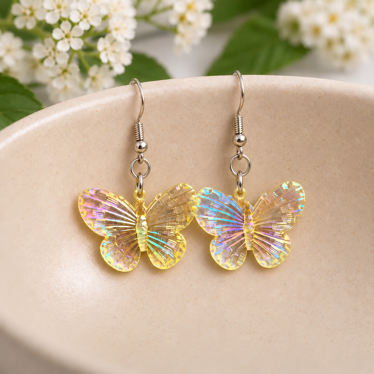 Lemon Aurora Butterfly Earrings resting in a speckled ceramic bowl