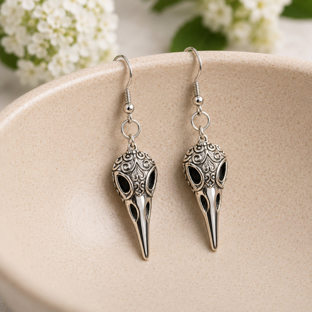 Ornate Bird Skull Earrings displayed in a lifestyle product photo