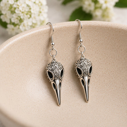 Ornate Bird Skull Earrings displayed in a lifestyle product photo