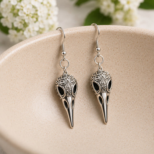 Ornate Bird Skull Earrings displayed in a lifestyle product photo