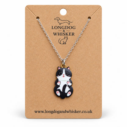 Black and White Belly Rub Cat Necklace on a silver-tone chain displayed on a Longdog & Whisker kraft card