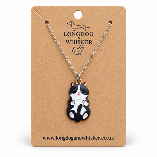 Black and White Belly Rub Cat Necklace on a silver-tone chain displayed on a Longdog & Whisker kraft card