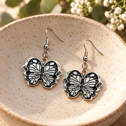 Black butterfly drop earrings in ceramic bowl