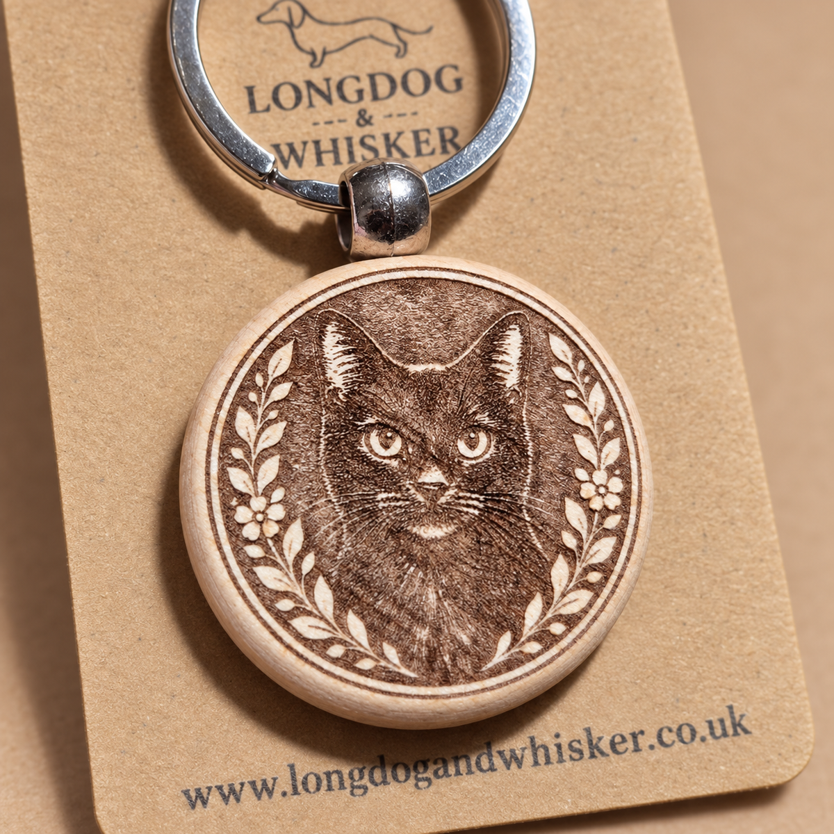 Close-up of the black cat engraving on a wooden keyring