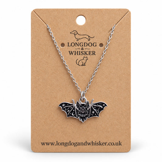 Black fanged bat necklace on a silver chain, displayed on a Longdog & Whisker kraft card