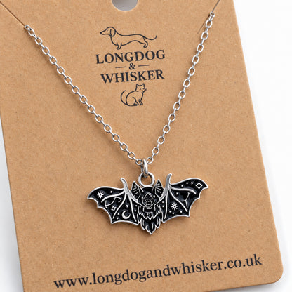 Close-up of the black fanged bat necklace showing its face and silver-tone wing patterns