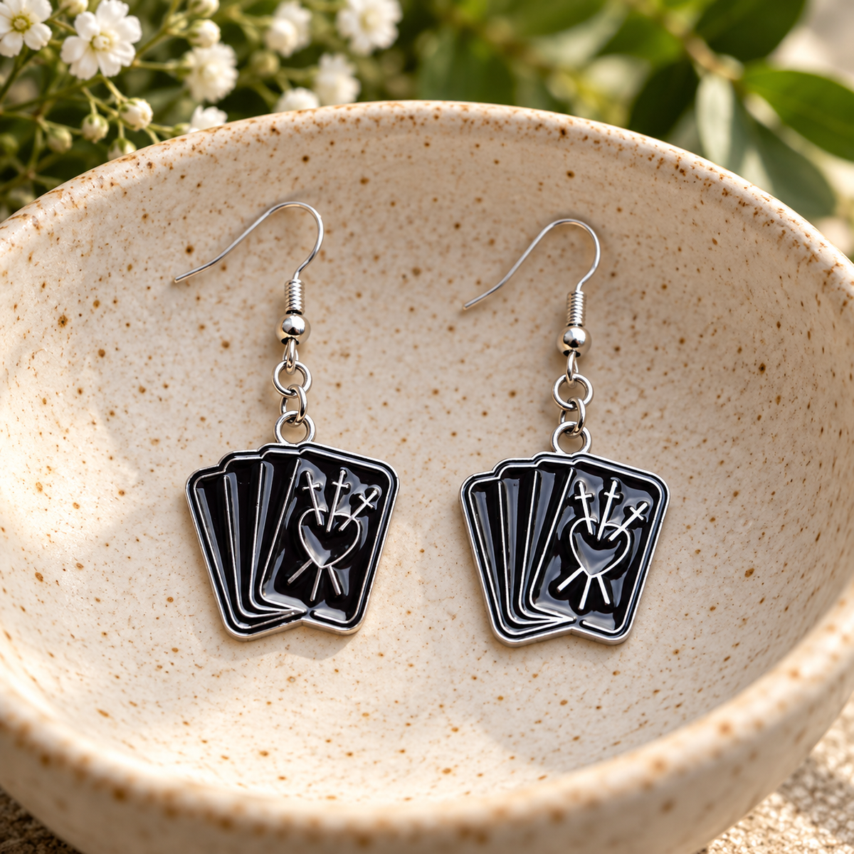 Black fortune teller card drop earrings in a speckled ceramic bowl