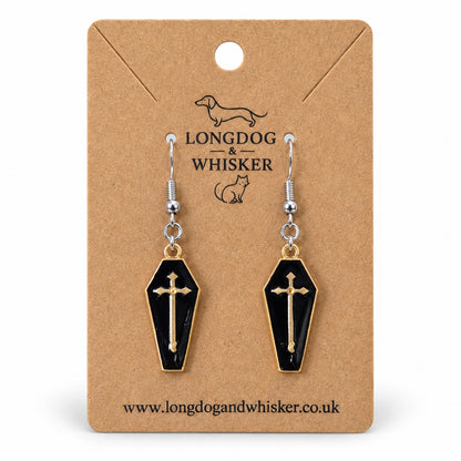 Black coffin cross earrings with gold-tone borders and silver-tone hooks on a Longdog & Whisker kraft card