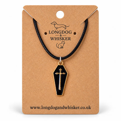 Black coffin necklace with gold-tone cross on black cord, displayed on a Longdog & Whisker kraft card