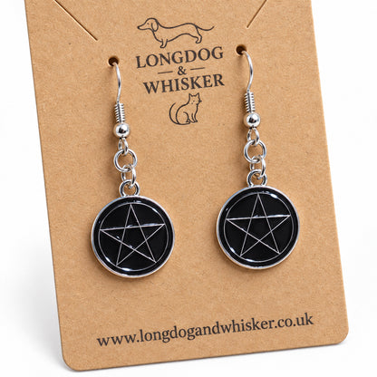 Close-up of glossy black pentagram earrings and silver-tone drop hardware