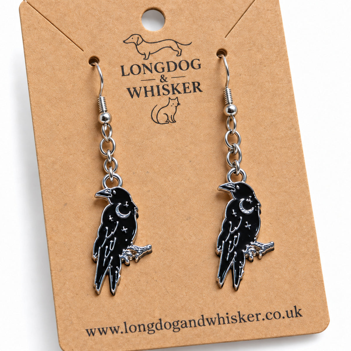 Close-up of black raven earrings with silver crescent moon details