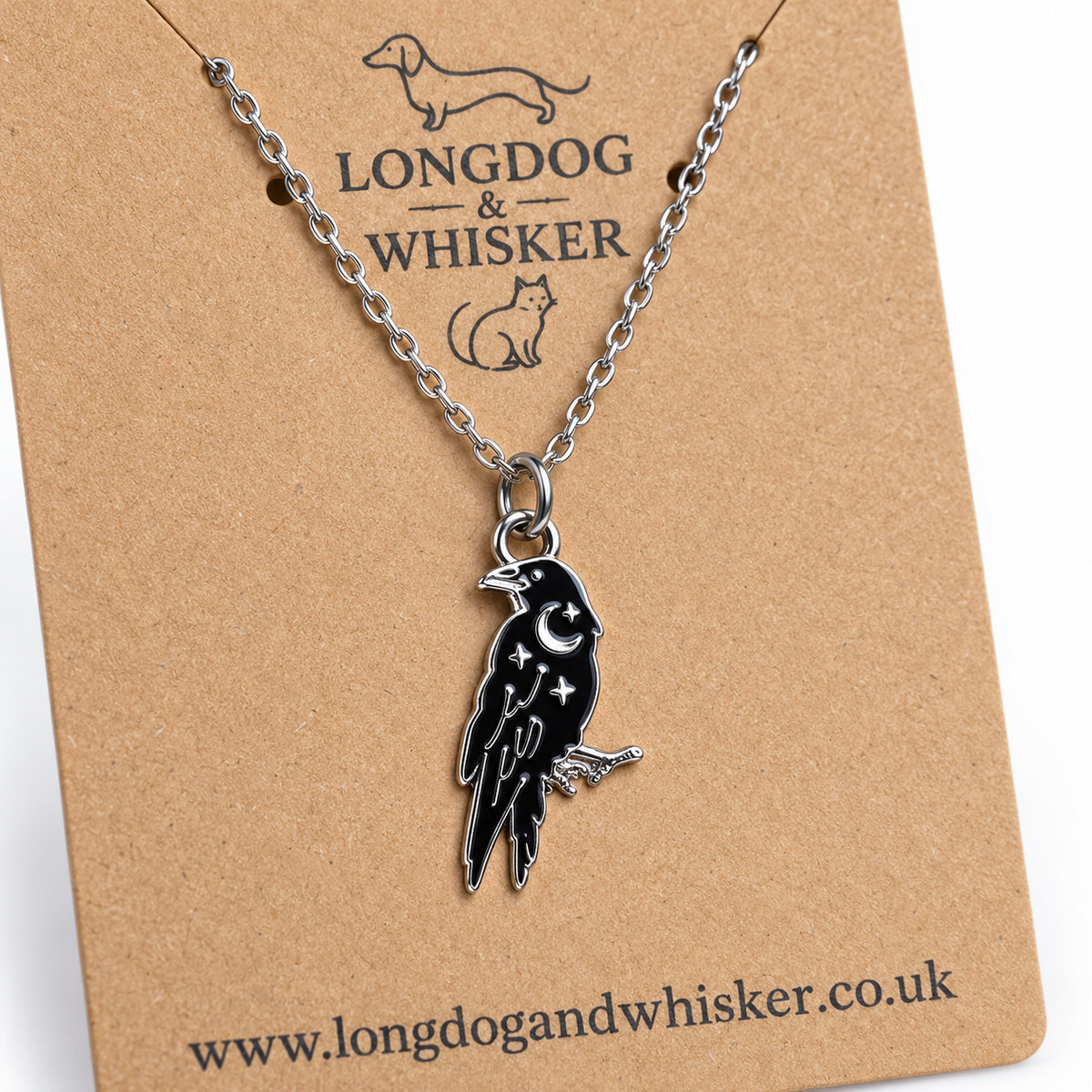 Close-up of the black raven pendant with silver-tone crescent moon, stars and feather details
