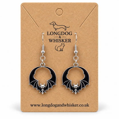 Black round wing bat drop earrings with silver-tone details on a Longdog & Whisker kraft card