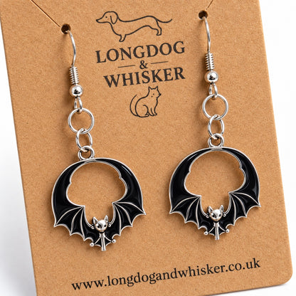 Close-up of black round wing bat earrings showing open centres and silver-tone wing ribs