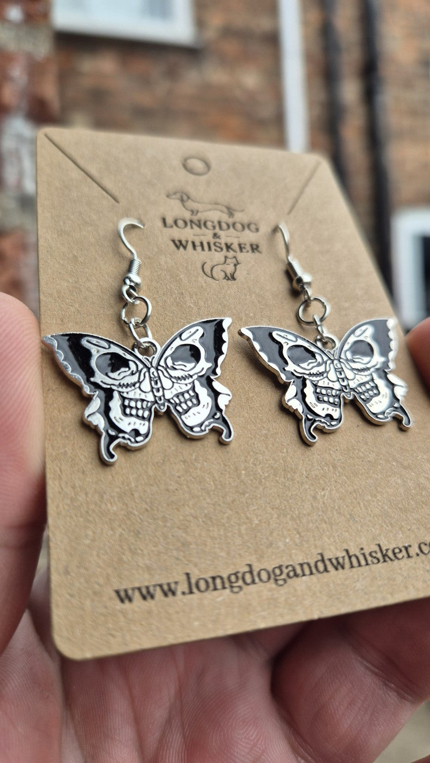 Close-up of the two skull faces on each black and silver butterfly earring