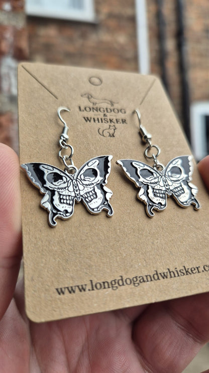 Close-up of the two skull faces on each black and silver butterfly earring