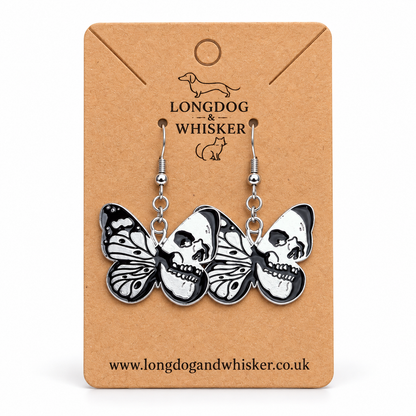 Black and silver skull butterfly drop earrings on a Longdog & Whisker kraft card