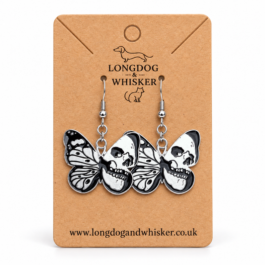 Black and silver skull butterfly drop earrings on a Longdog & Whisker kraft card