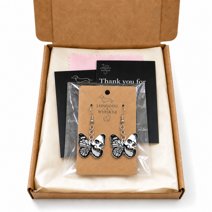 Black and silver skull butterfly drop earrings presented in Longdog & Whisker gift packaging