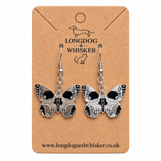 Black and silver skull-wing butterfly drop earrings on Longdog & Whisker card