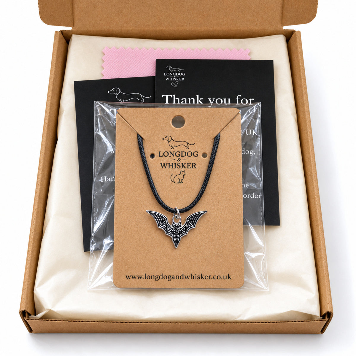 Black skeletal bat necklace on black cord in Longdog & Whisker gift-ready packaging