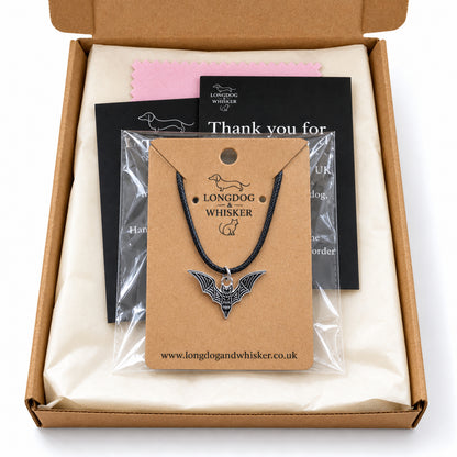Black skeletal bat necklace on black cord in Longdog & Whisker gift-ready packaging
