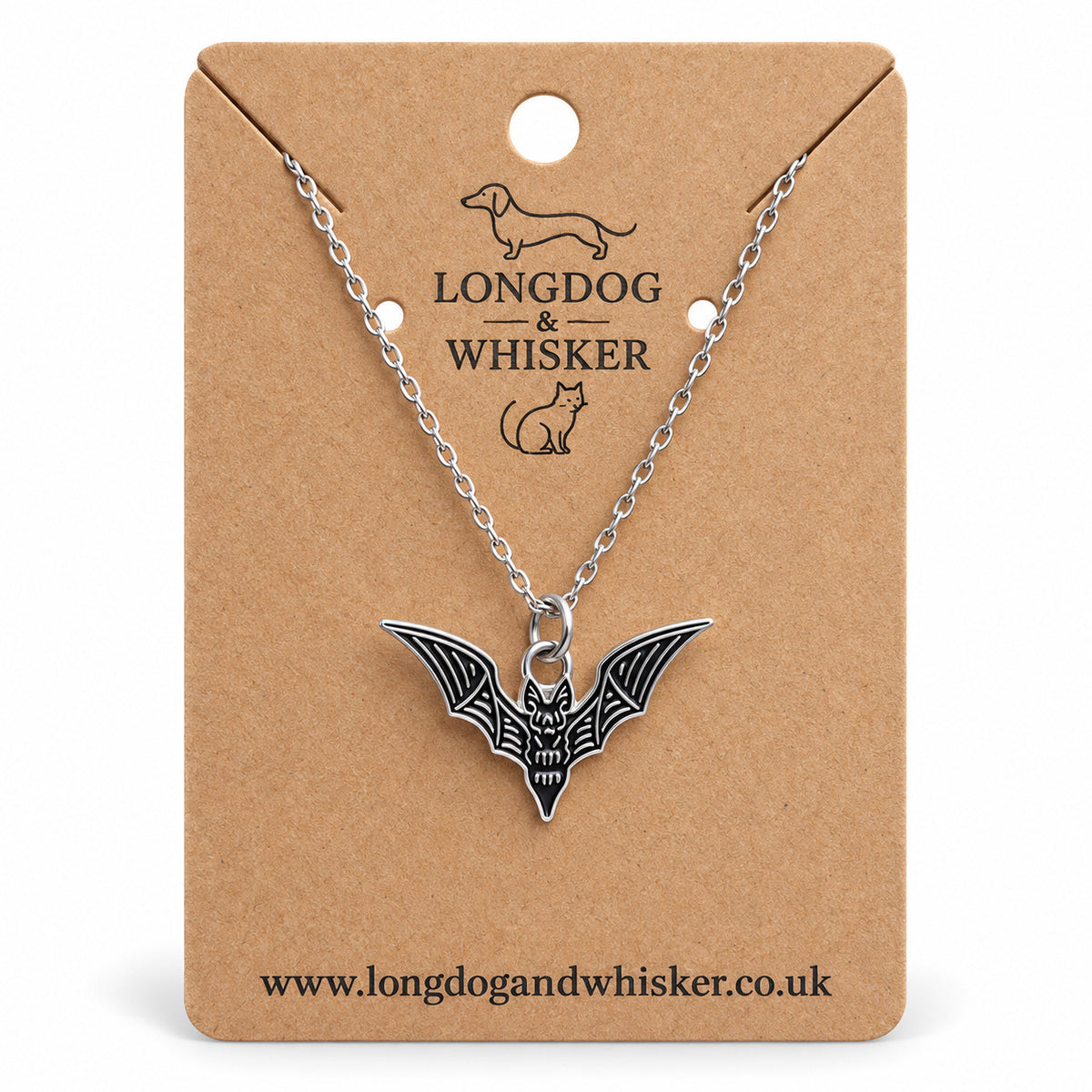 Black skeletal bat necklace on a silver chain, displayed on a Longdog & Whisker kraft card