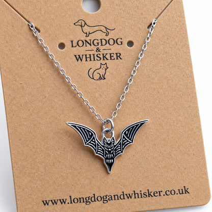 Close-up of the black skeletal bat necklace showing silver-tone wing bones and face details