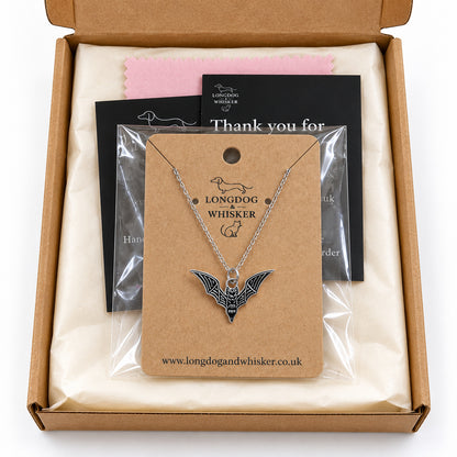 Black skeletal bat necklace on its card in Longdog & Whisker gift-ready packaging