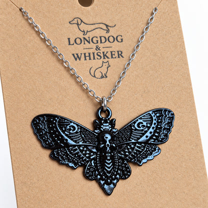Close-up of the raised skull and ornate wing patterns on the black moth pendant