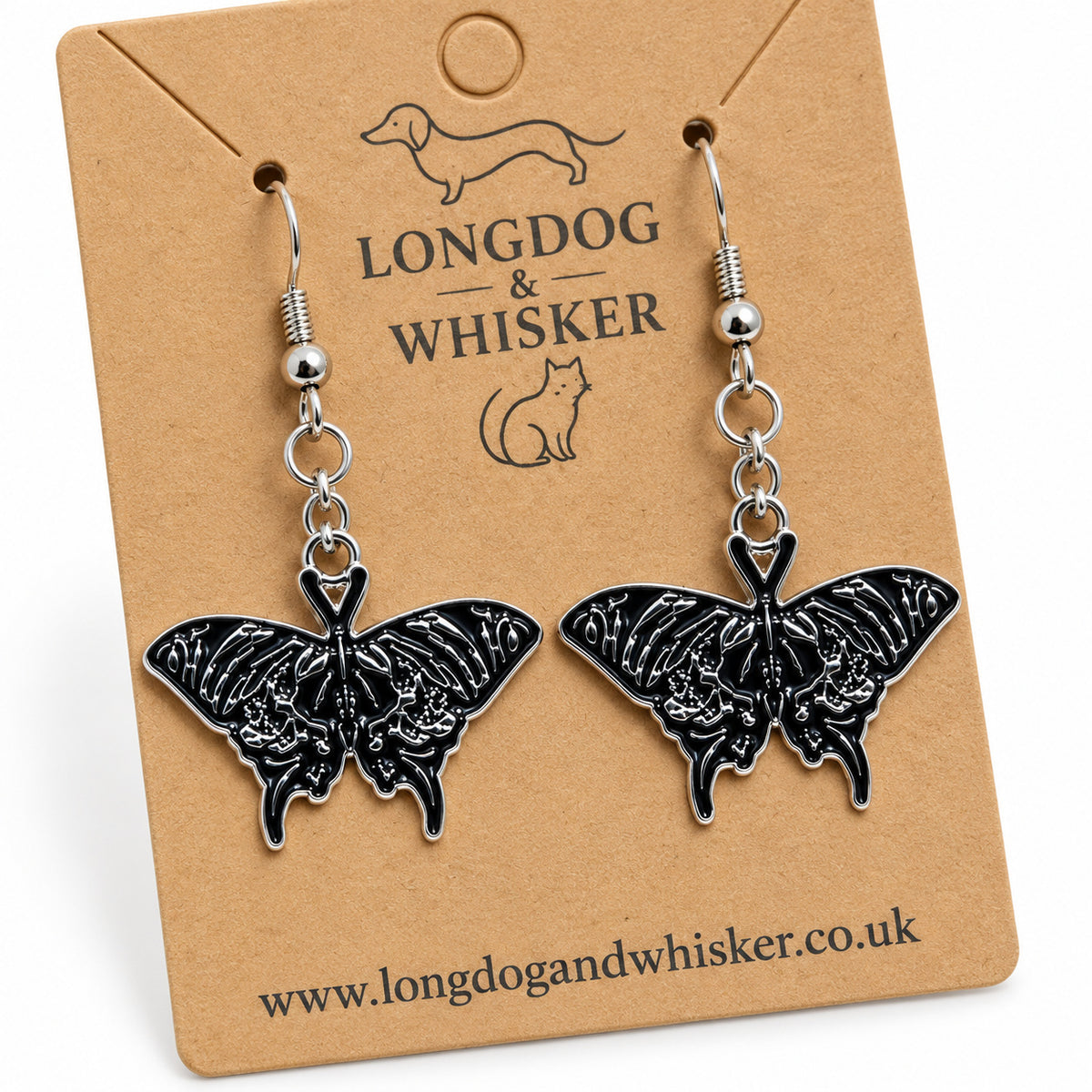 Close-up of black moth earrings with silver skull-like wing details