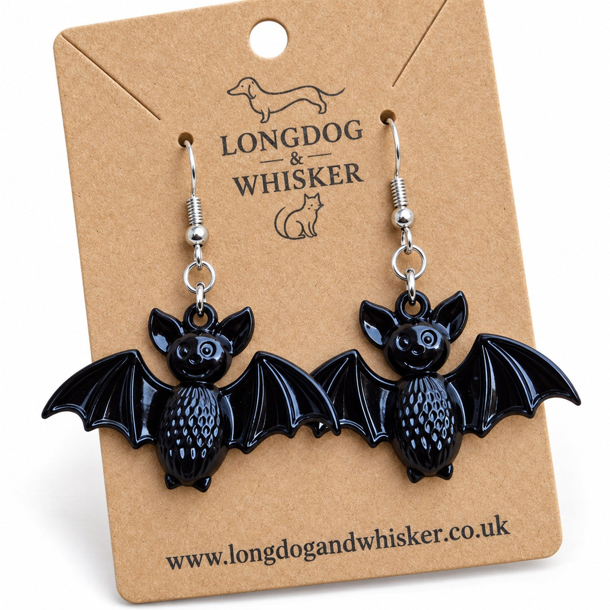 Close-up of black smiley bat earrings showing textured bodies, wing details and silver-tone hooks