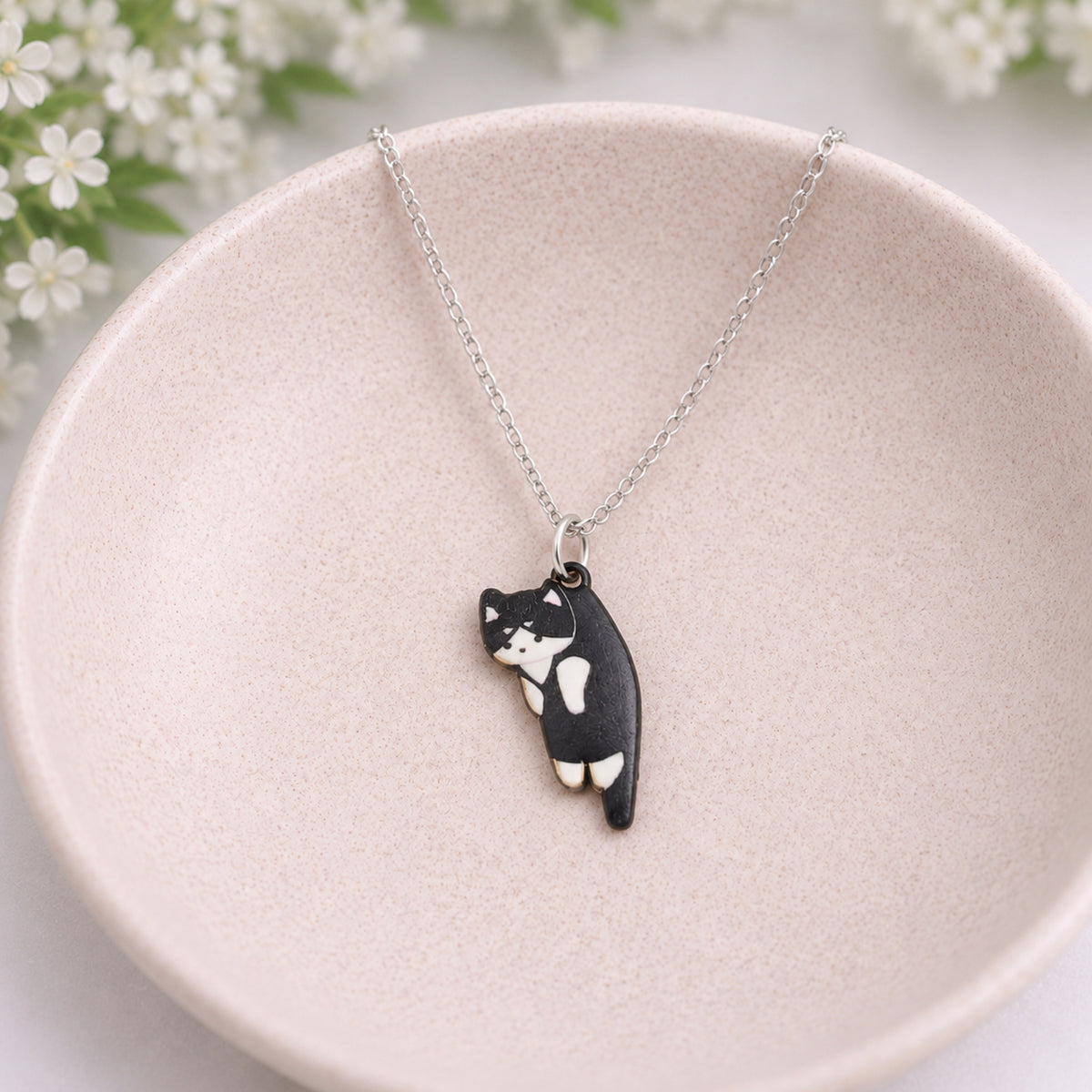 Scruffles Cat Necklace - Black & White displayed in a lifestyle product photo