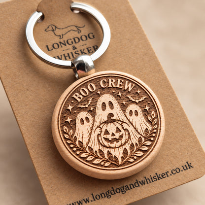 Close-up of Boo Crew ghosts and pumpkin engraving on round wooden keyring