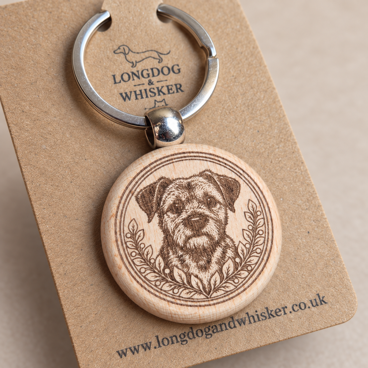 Close-up of Border Terrier portrait, leafy border, natural wood edge and silver connector